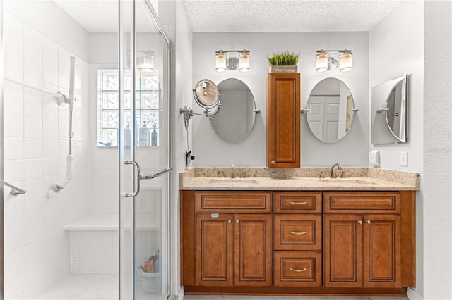 bathroom with vanity, walk in shower, and a textured ceiling