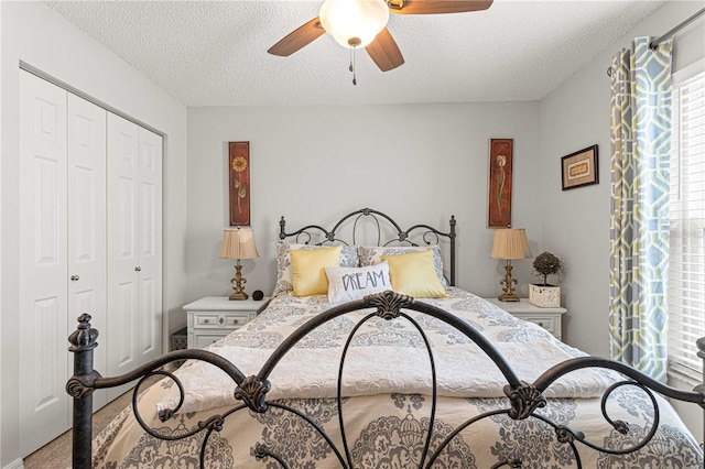 carpeted bedroom featuring a textured ceiling, a closet, and ceiling fan