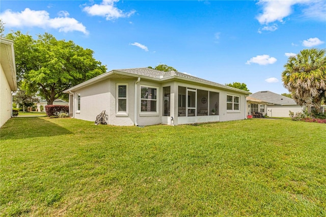 back of house with a yard and a sunroom