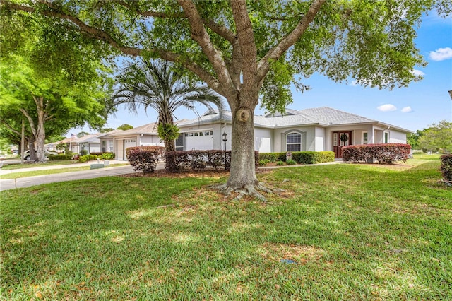 ranch-style home with a garage and a front lawn