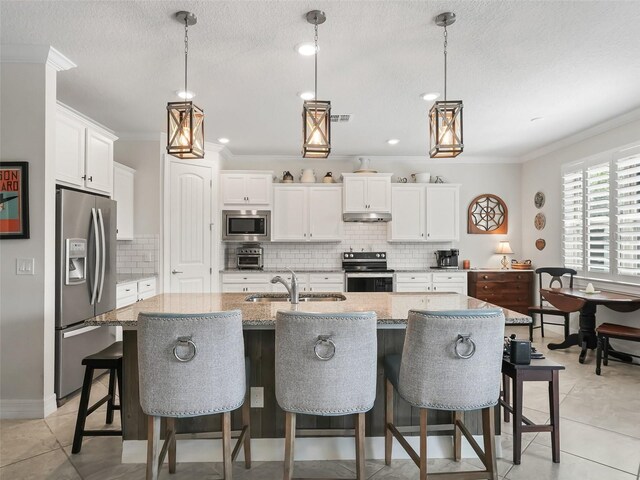 kitchen featuring sink, appliances with stainless steel finishes, a kitchen island with sink, and white cabinetry