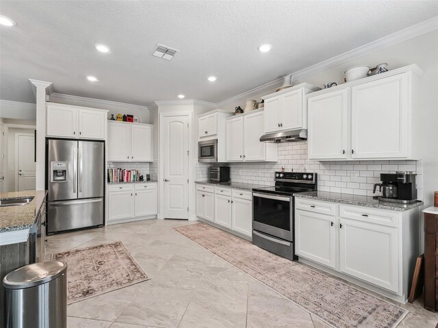 kitchen with white cabinetry, light stone counters, and appliances with stainless steel finishes