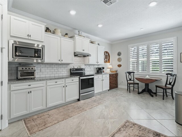 kitchen featuring stainless steel appliances, ornamental molding, and white cabinets