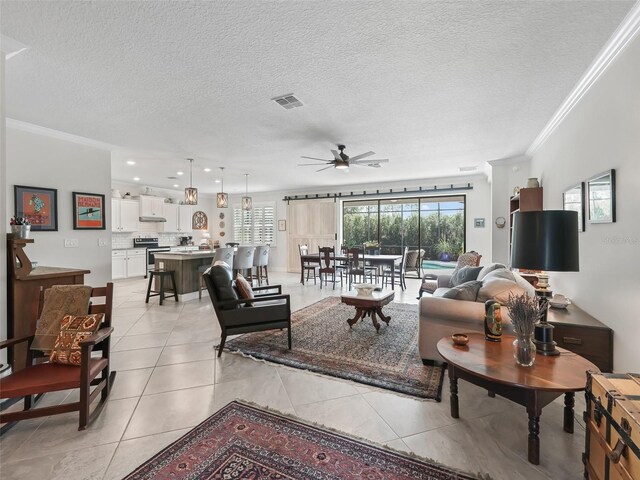 tiled living room with ornamental molding, a textured ceiling, and ceiling fan