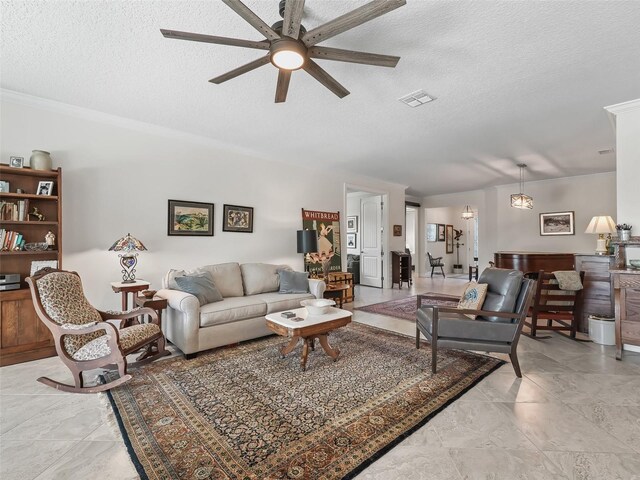 living room featuring ornamental molding, a textured ceiling, and ceiling fan