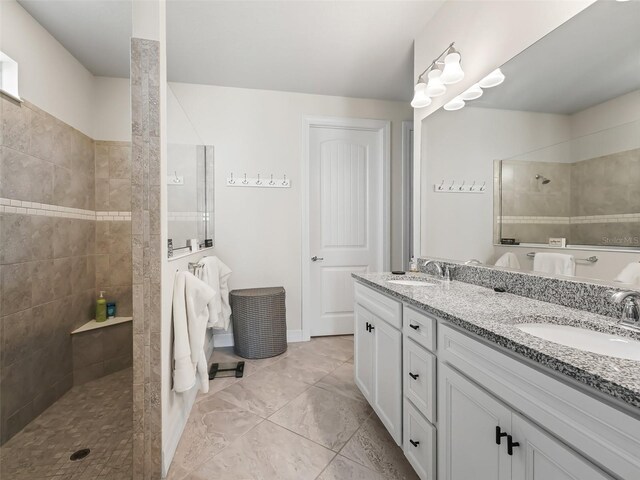 bathroom with a tile shower and vanity