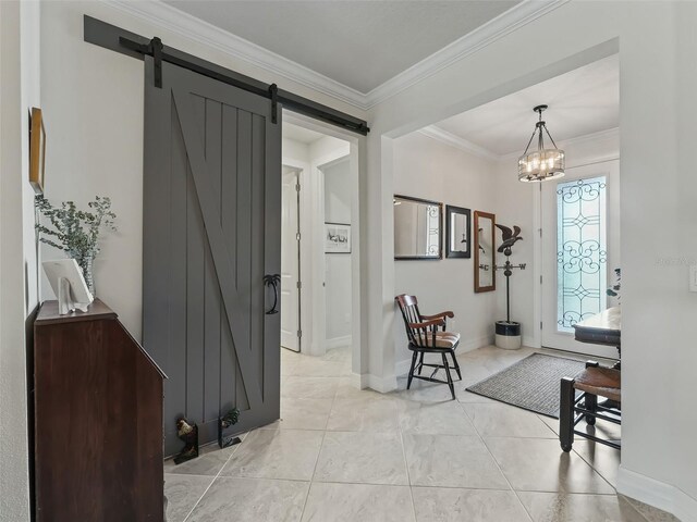 foyer featuring crown molding, a barn door, and a notable chandelier