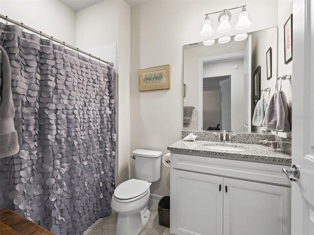 bathroom with vanity, toilet, and tile patterned flooring