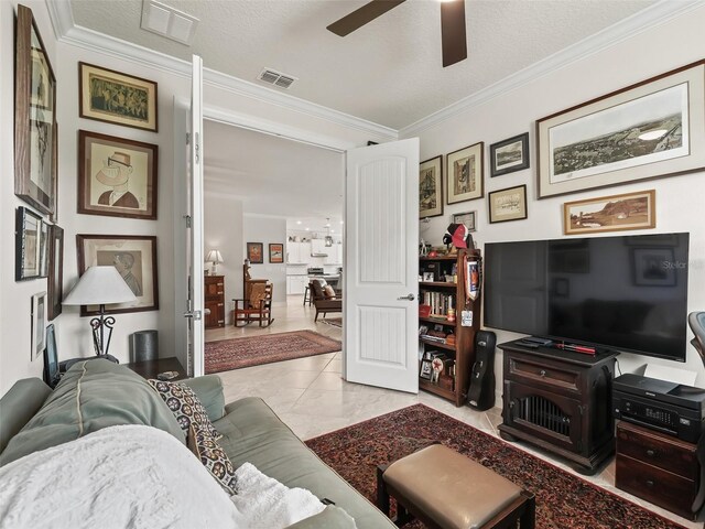 living room featuring ornamental molding, a textured ceiling, light tile patterned floors, and ceiling fan