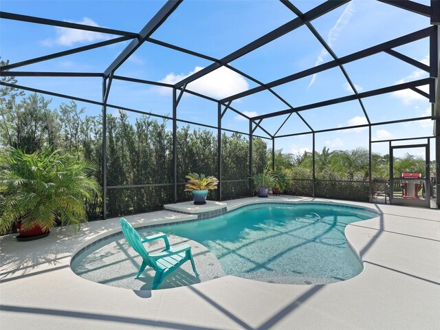 view of swimming pool with a patio and glass enclosure