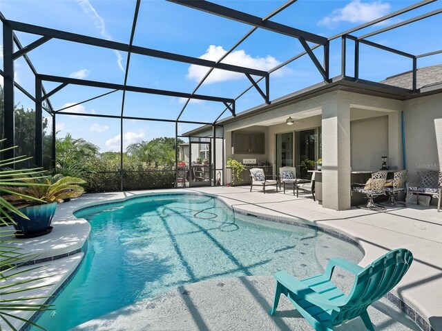 view of pool with a patio, a lanai, and ceiling fan