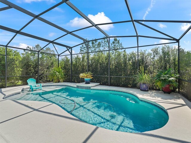 view of pool featuring a patio and glass enclosure