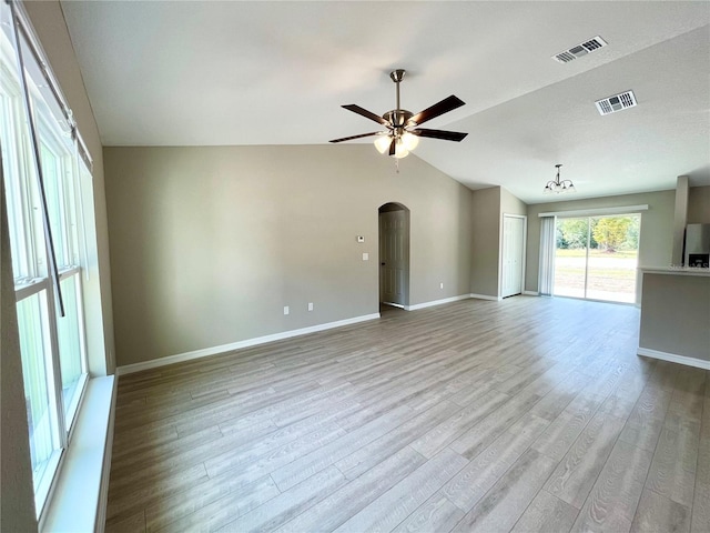 unfurnished living room featuring light wood-style floors, arched walkways, visible vents, and ceiling fan