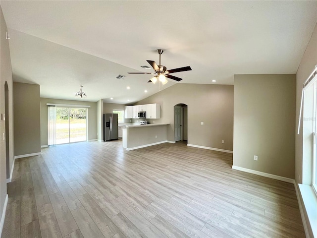 unfurnished living room with arched walkways, lofted ceiling, visible vents, ceiling fan, and light wood-type flooring