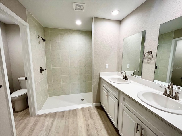 bathroom featuring visible vents, a sink, toilet, and wood finished floors