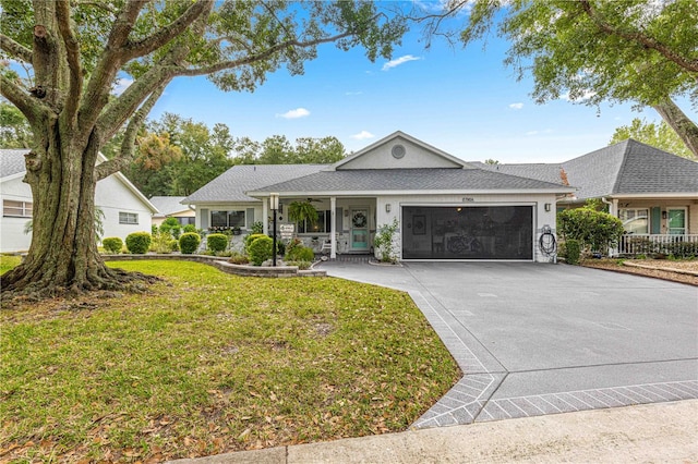 ranch-style house with a front yard, a garage, and covered porch