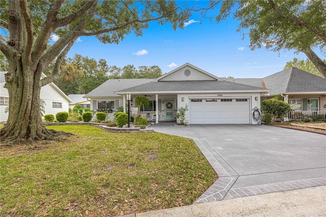 single story home with a front yard, covered porch, and a garage