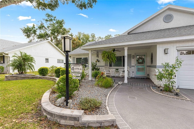 property entrance with a porch, a garage, and a lawn