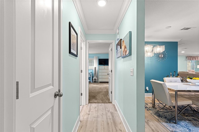 hallway featuring ornamental molding and light hardwood / wood-style flooring