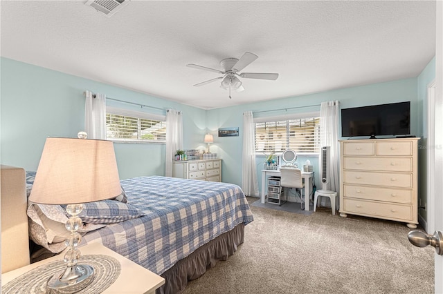 bedroom with ceiling fan, carpet, and multiple windows