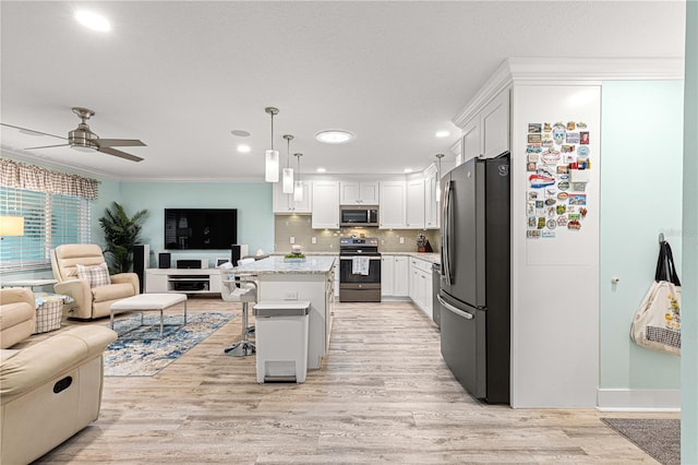 kitchen featuring stainless steel appliances, a kitchen breakfast bar, a kitchen island, and white cabinets