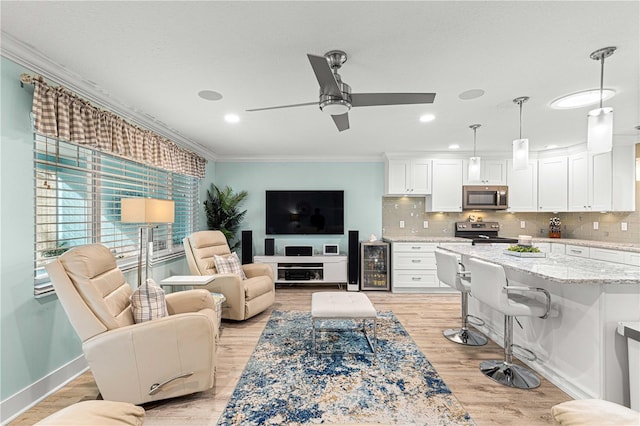 living room with light hardwood / wood-style floors, crown molding, wine cooler, and ceiling fan