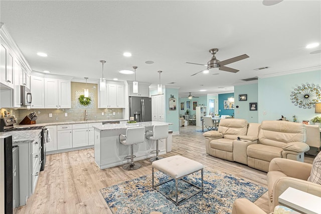 living room featuring light hardwood / wood-style floors, ornamental molding, sink, and ceiling fan