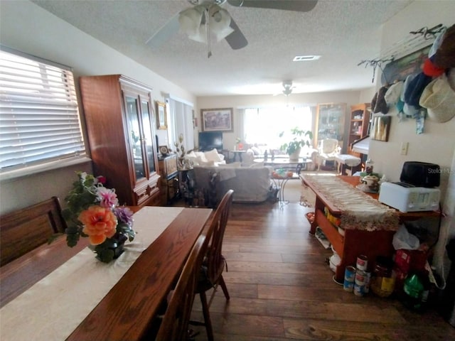 dining room with a textured ceiling, ceiling fan, dark hardwood / wood-style floors, and plenty of natural light