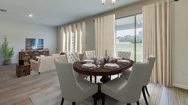 dining space with light hardwood / wood-style flooring, a textured ceiling, and a healthy amount of sunlight