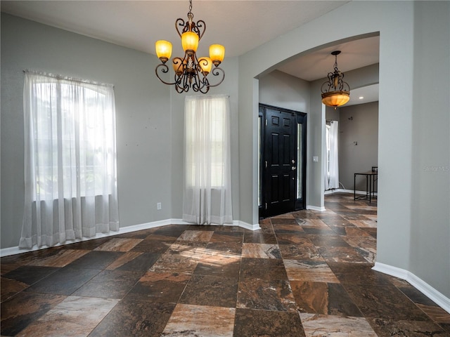 entrance foyer featuring a wealth of natural light and a notable chandelier