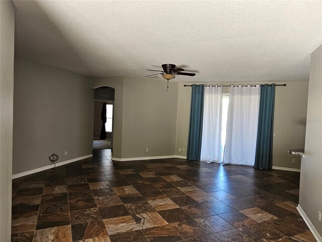 empty room featuring a textured ceiling and ceiling fan