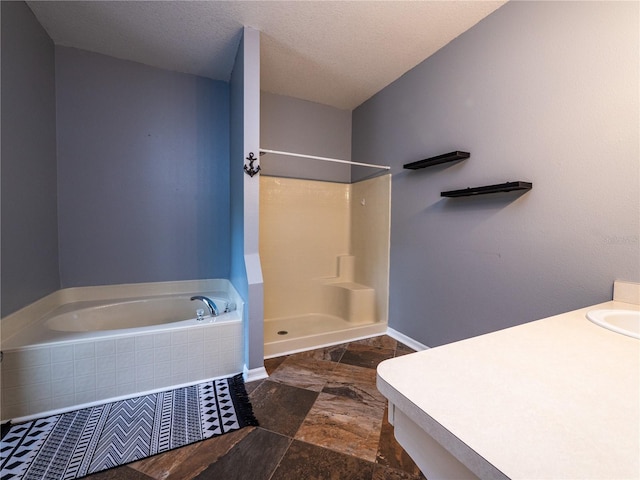 bathroom featuring vanity, shower with separate bathtub, and a textured ceiling