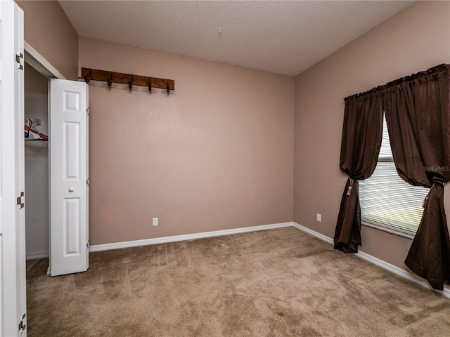 carpeted spare room featuring a textured ceiling