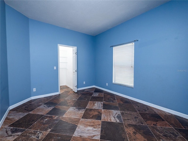 unfurnished room with a textured ceiling