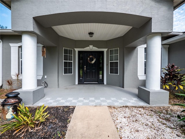 12805 SW 64th Ln, Ocala, FL 34481 - doorway to property featuring covered porch and stucco siding