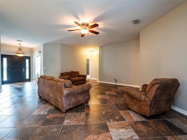 12805 SW 64th Ln, Ocala, FL 34481 - living room featuring a ceiling fan, arched walkways, baseboards, and stone tile floors