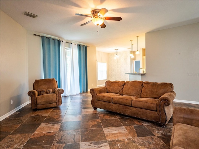 12805 SW 64th Ln, Ocala, FL 34481 - living area featuring a ceiling fan, stone tile floors, and baseboards
