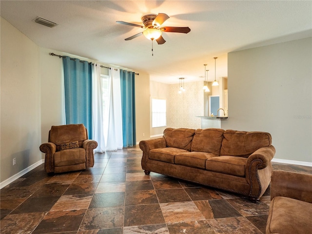 12805 SW 64th Ln, Ocala, FL 34481 - living area featuring a ceiling fan, stone tile flooring, and baseboards