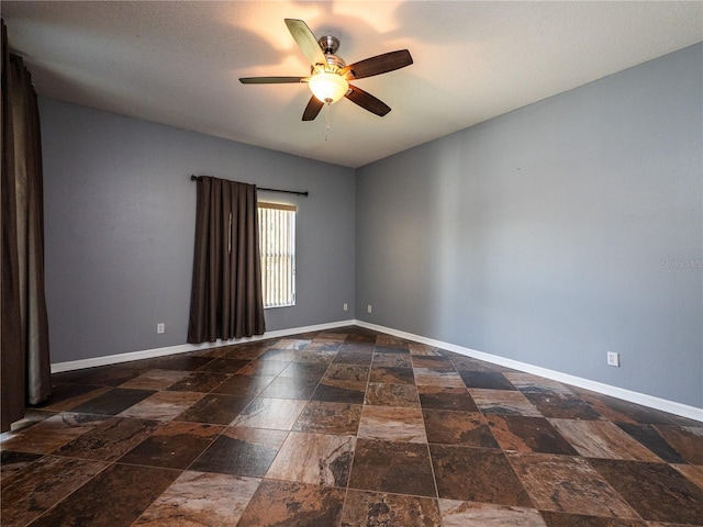 12805 SW 64th Ln, Ocala, FL 34481 - spare room with stone tile flooring, a ceiling fan, and baseboards