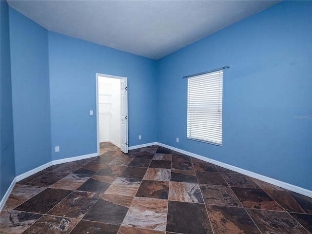 12805 SW 64th Ln, Ocala, FL 34481 - spare room featuring stone tile flooring and baseboards