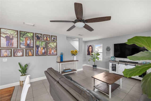 tiled living room featuring ceiling fan and a textured ceiling