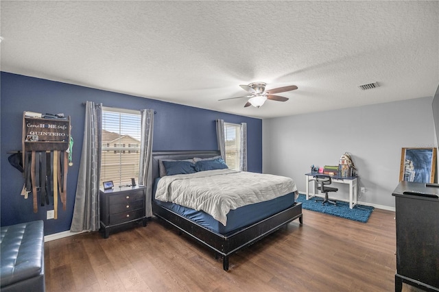 bedroom featuring a textured ceiling, dark wood-type flooring, and ceiling fan