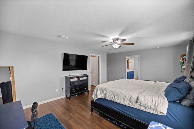 bedroom featuring connected bathroom, dark wood-type flooring, a textured ceiling, and ceiling fan