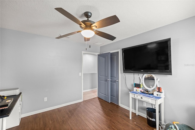 interior space featuring ceiling fan, a textured ceiling, and dark hardwood / wood-style flooring