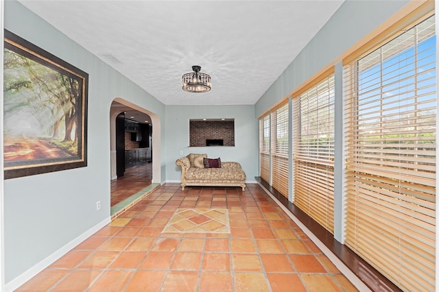 hallway featuring tile patterned floors and a textured ceiling