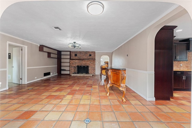 unfurnished living room with ornamental molding, a fireplace, and light tile patterned floors