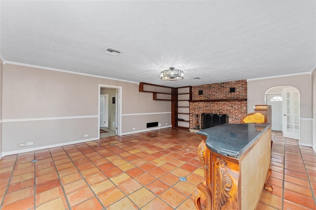 unfurnished living room with crown molding, tile patterned flooring, and a brick fireplace