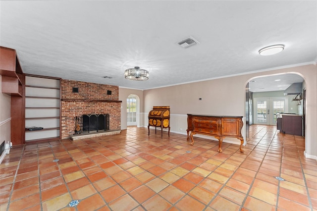 unfurnished living room featuring ornamental molding, a fireplace, a healthy amount of sunlight, and light tile patterned floors