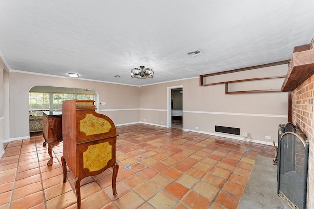 tiled living room with ornamental molding and a brick fireplace