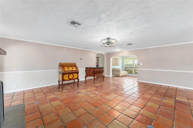 unfurnished room featuring crown molding, a textured ceiling, an inviting chandelier, and tile patterned flooring